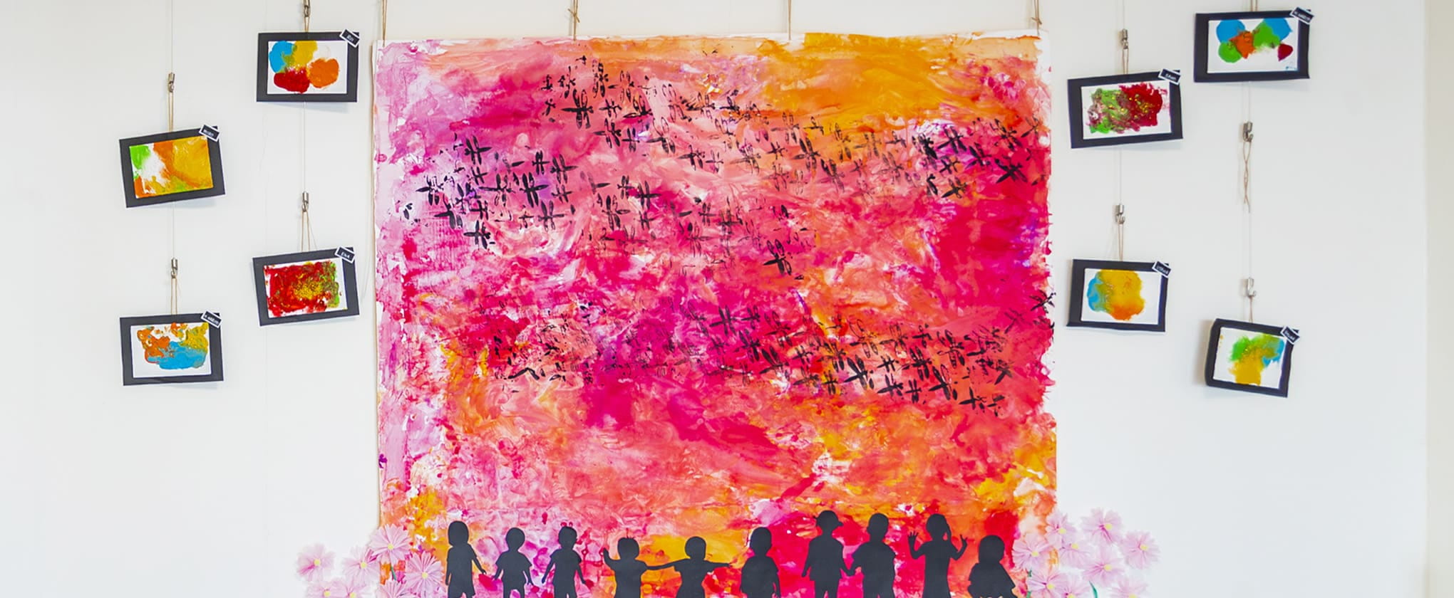 赤やオレンジを基調にした夕焼け空にトンボが飛ぶ大きな共同制作作品