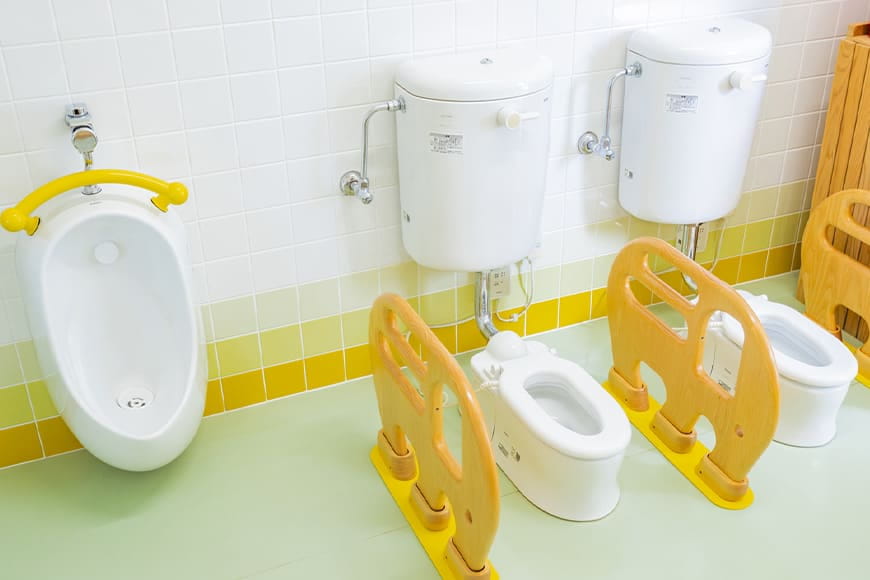 子どもが使いやすいように設計された低い便器と黄色い手すり付きの便座